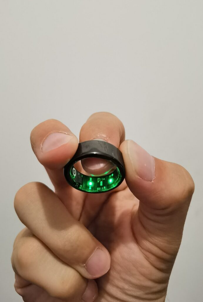 Close-up of a Xiaomi Smart Ring, showing the internal green LED sensors and circuitry activated, illustrating the sophisticated technology used for health tracking